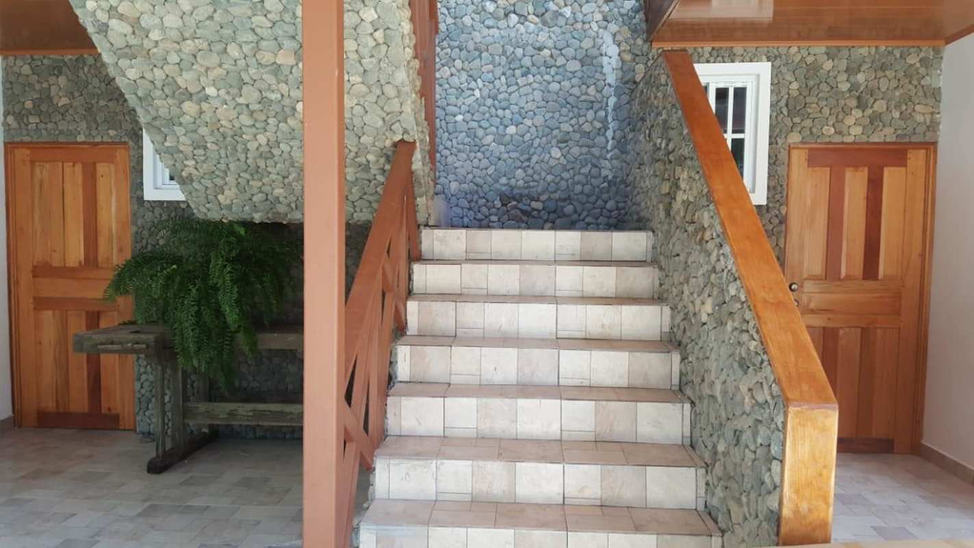 Indoor staircase with rustic stone walls and wooden railings in Cerro Azul Panama
