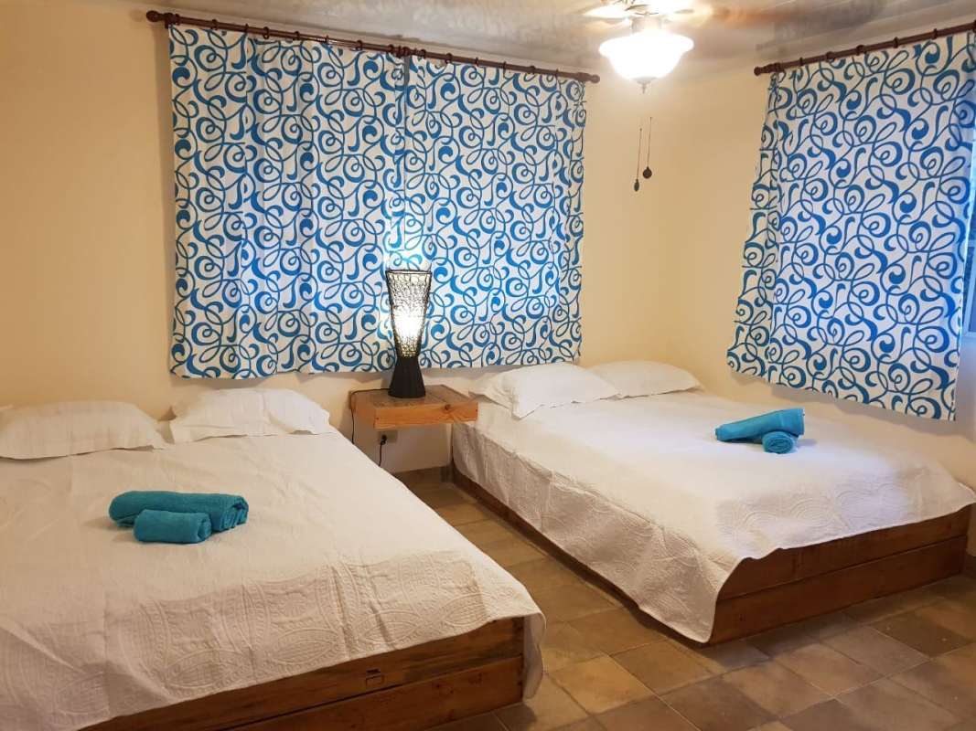 Simple bedroom with twin wooden beds and nature views in Cerro Azul Panama