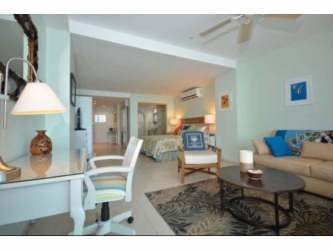 Bright open-plan studio apartment with coastal decor, bed, seating area at Coronado Bay Panama