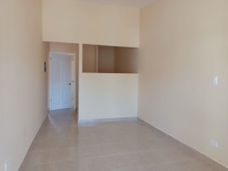 Simple empty bedroom with beige walls and window at remodeled Vacamonte house