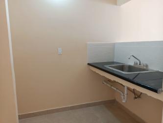 Simple kitchenette with black countertop in remodeled affordable home Valle de Los Cerezos Arraiján
