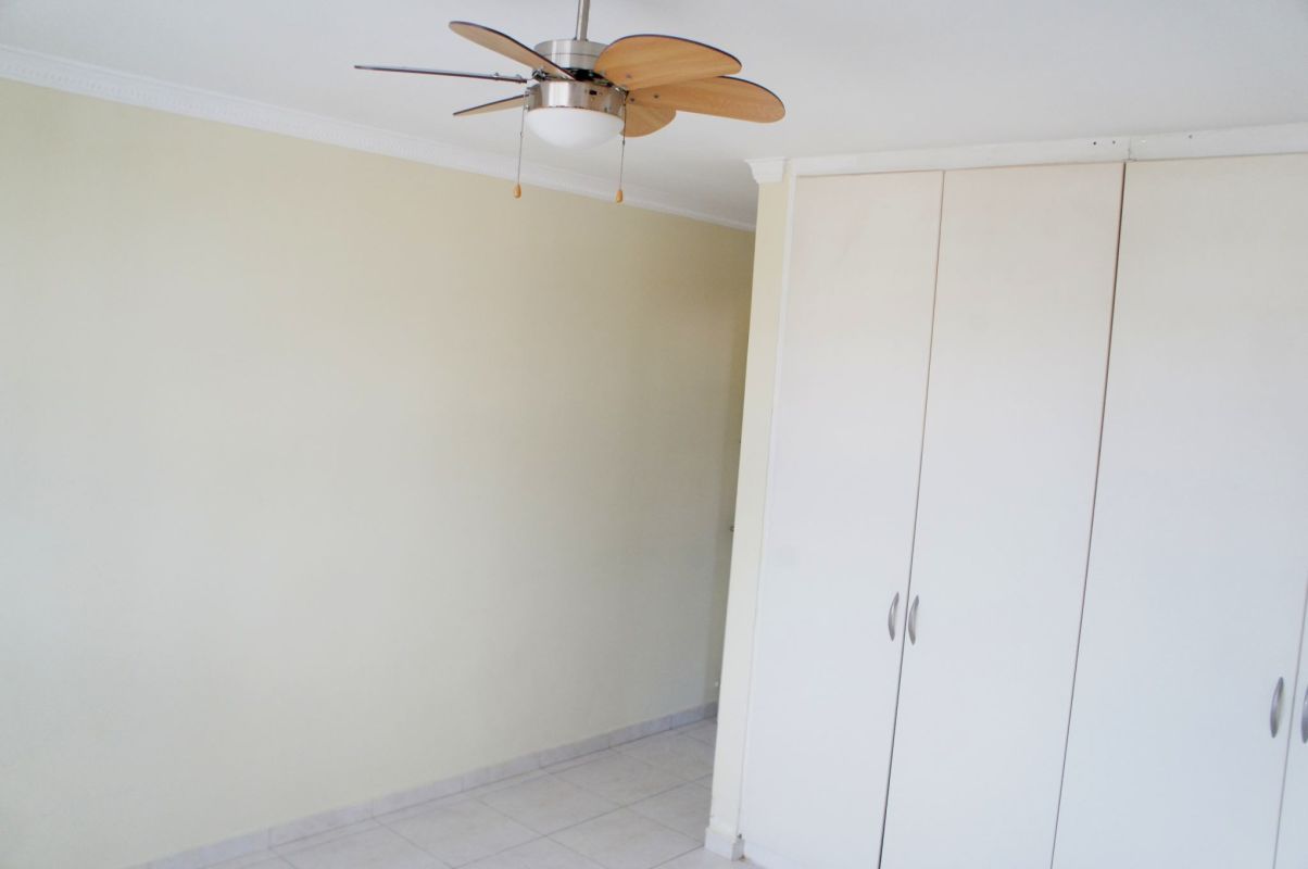 Minimalist bedroom with ceiling fan built-in closet PH Metro Park View Panama