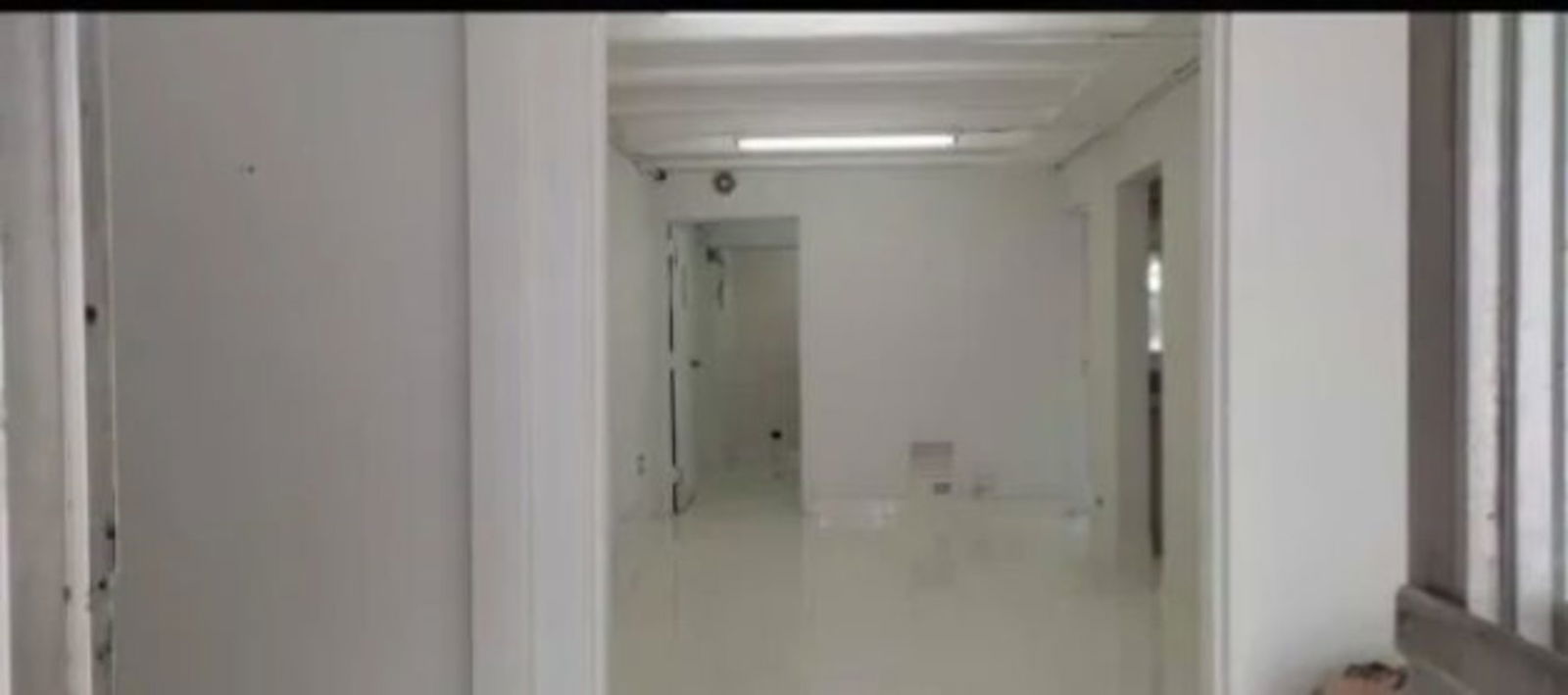 Bright corridor with white walls and multiple access doors in commercial complex Edificio Z1 Panama City