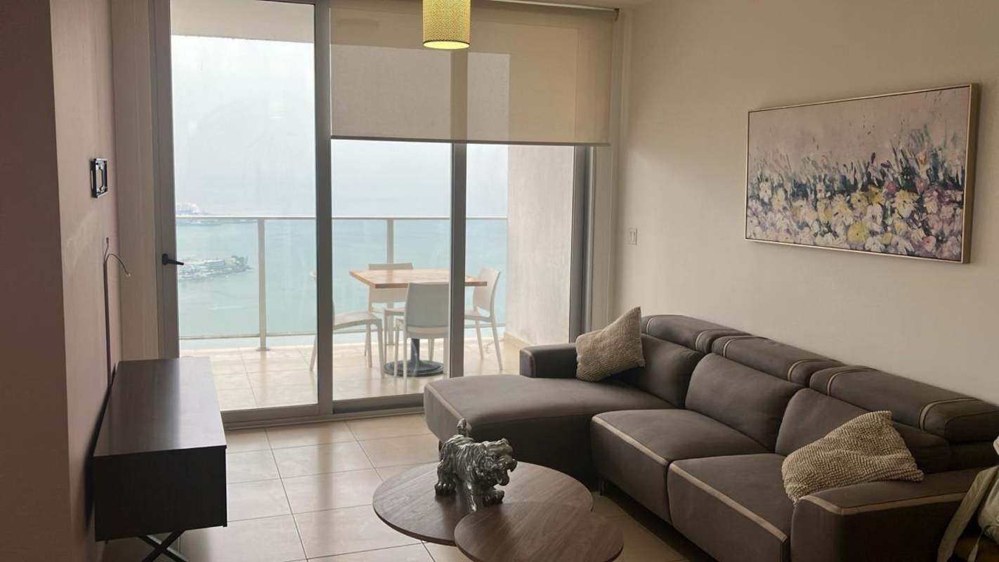 Open plan living and dining room with balcony and ocean views in PH White Tower Panama