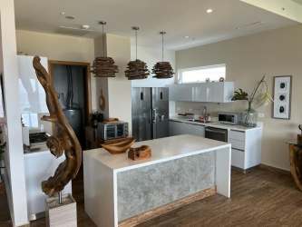 Elegant dining room with marble table, wood accents and natural light in Playa Escondida condo Portobelo Panama