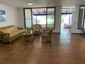 Mediterranean style living room with terracotta tiles and wicker furniture at Coronado duplex home