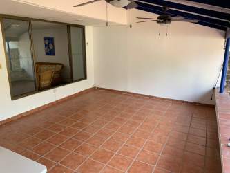 Large enclosed patio with terracotta floors, ceiling fans, sliding windows at Coronado Beach duplex