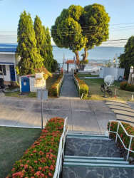 Exterior walkway with flower beds, trees and water views in Coronado beachside community duplex