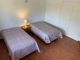 Simple twin bedroom with closet, nightstand and tiled floor inside Coronado Panama beach duplex