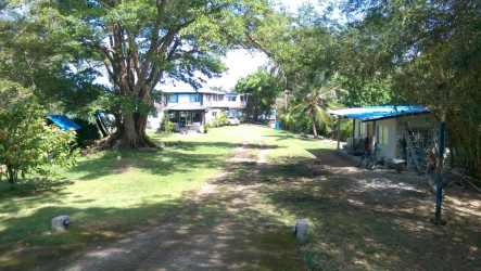 Two-story residence, green lawn, large trees in Colon Bayside Estate Panama