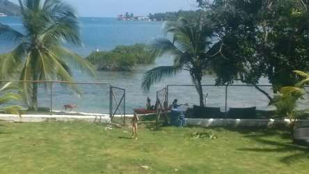 Oceanfront palms, lawn, fence in tropical property Panama Caribbean coast