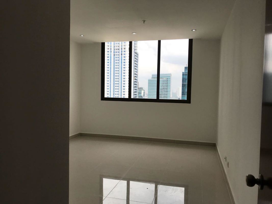 Empty modern bedroom with floor to ceiling windows overlooking Costa del Este skyline