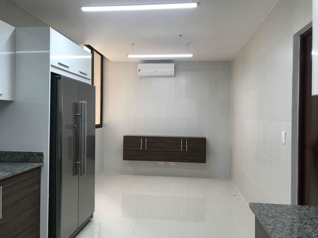 Spacious kitchen with granite counters stainless refrigerator dark cabinetry PH Brisa Marina Panama