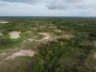 Aerial shot of natural undeveloped flat land with dirt paths and vegetation in Penonomé