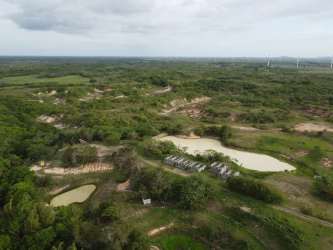Large area of flat land with multiple ponds and distant wind turbines near Penonomé Coclé