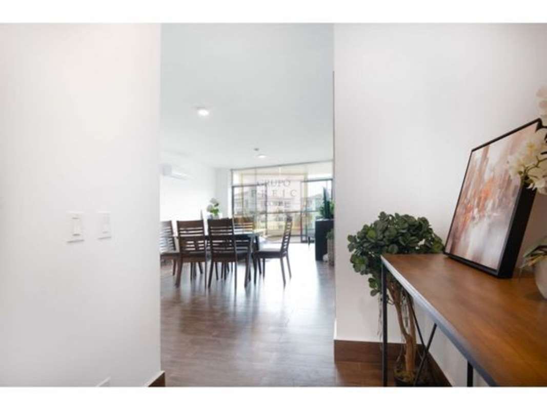 Modern bathroom with glass-enclosed shower, wood vanity, large mirror in Residencial Costamare apartment Panama City