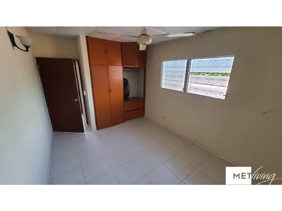 Bedroom with built-in wooden closet ceiling fan iron window bars Panama