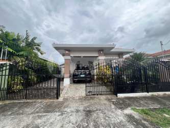 Secure gated entrance with car parked under covered carport in La Villa de Los Santos house for sale