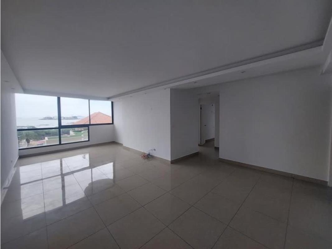 Living room with natural light, large window, ocean and city view in Panama apartment