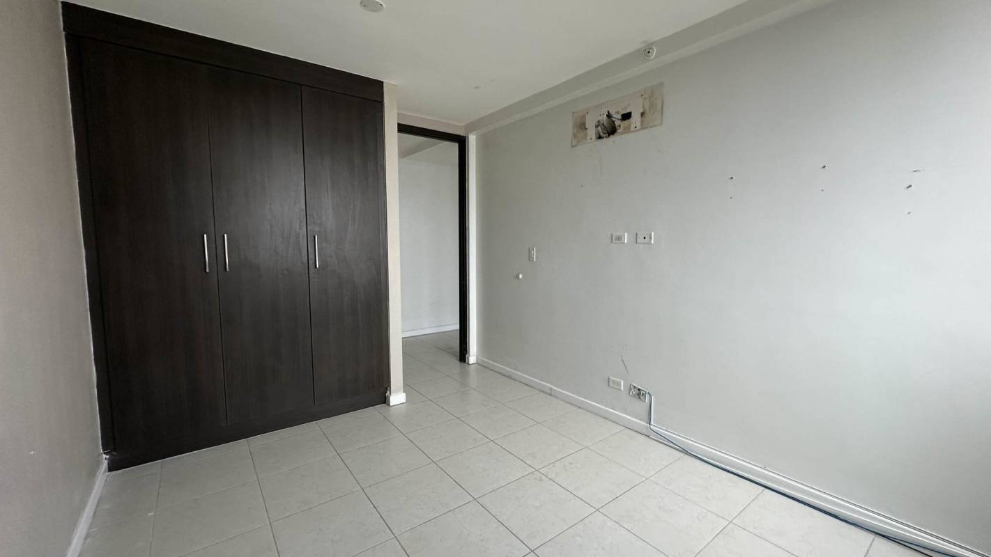Empty bedroom with large window, built-in closet, tiled floors PH Miro Panama City