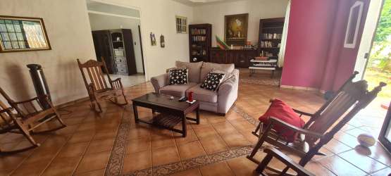 Bright kitchen and dining room with wood furniture, windows opening to garden Espave near Coronado beaches