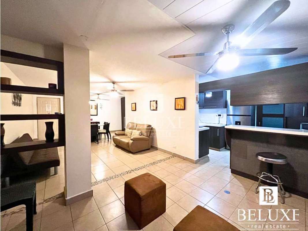 Kitchen area with gas cooktop, microwave, window blinds, ceiling fan in Betania Villa Aurora Panama apartment