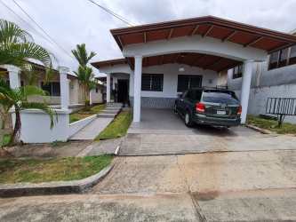 Exterior view of single-level house with front porch, covered carport, and landscaped yard Colinas del Sol