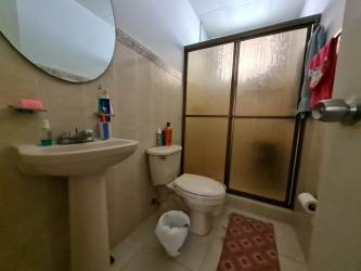 Full bathroom with pedestal sink, frosted shower doors, beige tile at Colinas del Sol home