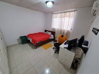Bedroom with white built-in closet, AC, neutral floor tiles Colinas del Sol family home