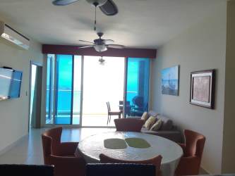 Modern open living room with balcony and ocean views at PH Santa Clara Residences Panama