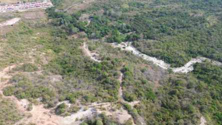 Aerial farmland with creek, wooded areas and open clearings at El Higo Panama