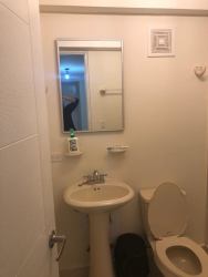 Modern bathroom with glass shower enclosure, toilet, pedestal sink PH Altamarina Playa Dorada