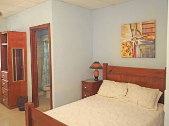 Two-story guest house with balconies, palm trees and tropical landscaping La Paz de Chame Panama