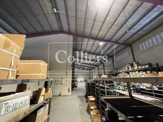 Large interior with high ceilings and industrial shelving France Field Zona Libre