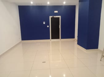 Interior retail space with blue accent wall, tiled floor, and recessed lighting at Westland Mall Panama