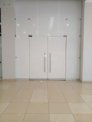 Empty commercial showroom with glass doors, neutral walls, and tiled floors at Westland Mall Panama