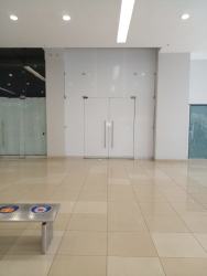 Clean bathroom with white tiles, sink, toilet, paper towel dispenser in Westland Mall La Chorrera