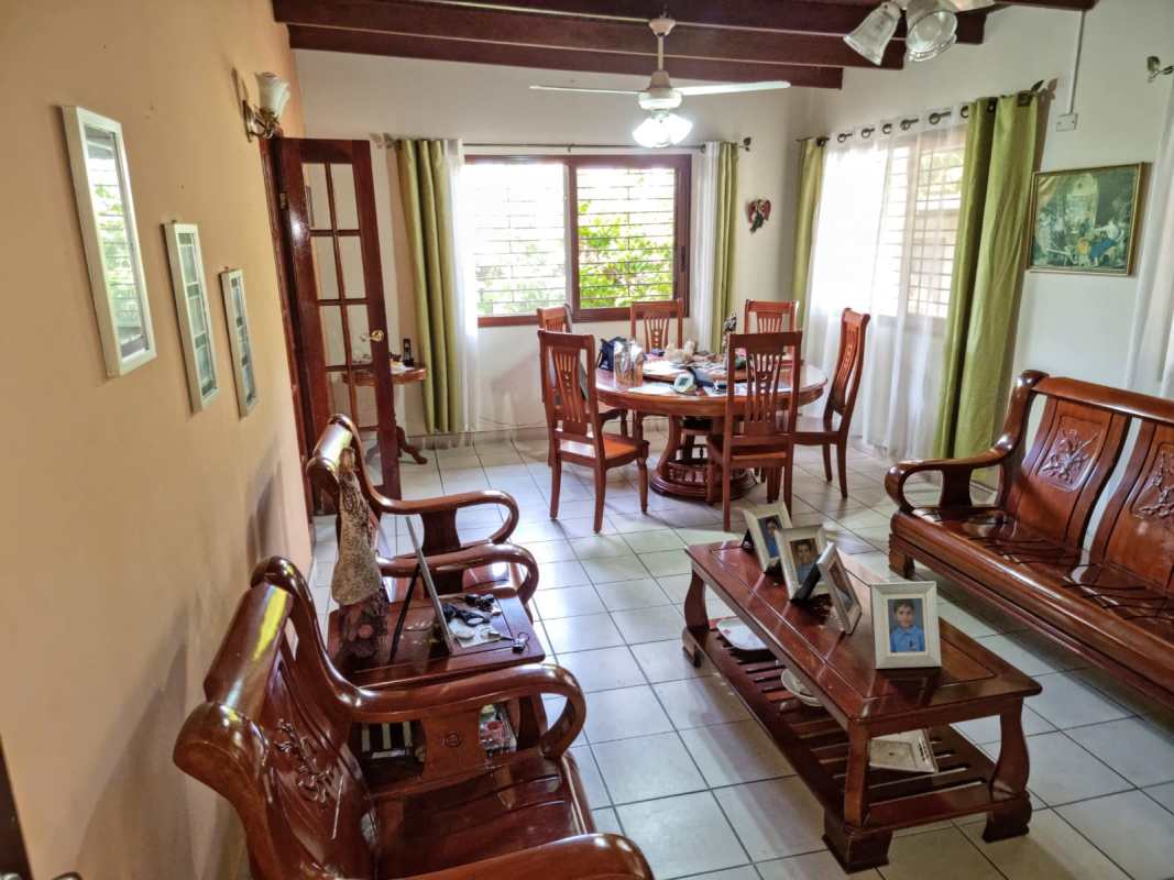 Living room with exposed beams, wooden furniture, tiled floor at Betania house Panama