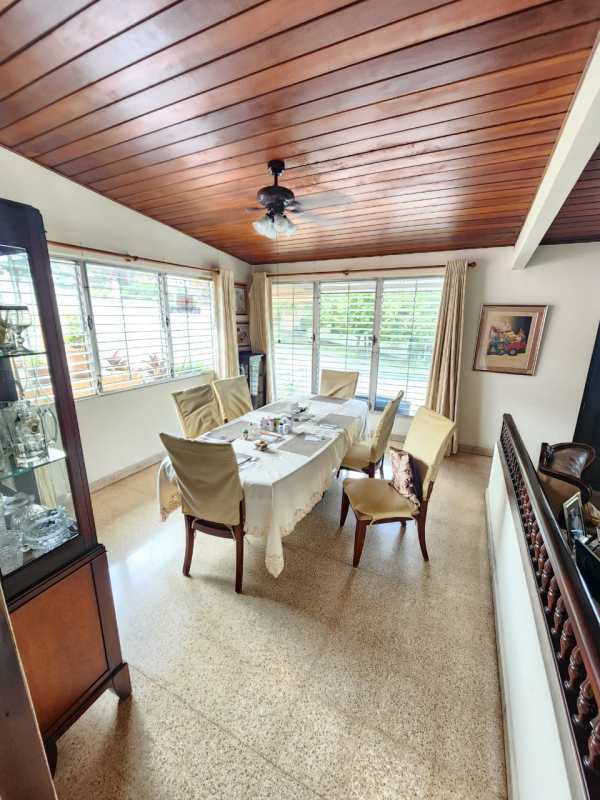 Traditional dining area with wood ceiling, natural light, set for six in Betania house Panama City
