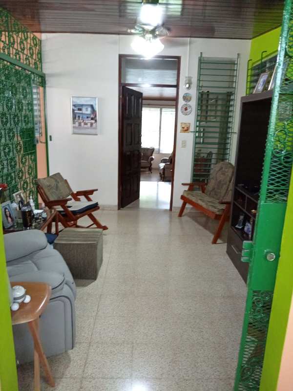 Traditional entrance hallway with metal gate, green wall paint and tile floor Betania family house Panama