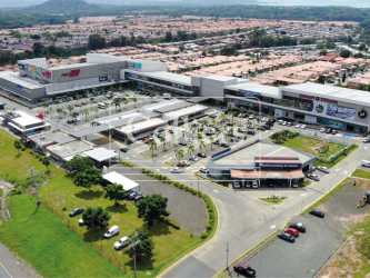 Front facade of Plaza OnDGo shopping center with parking and multiple retail stores in Panama Oeste