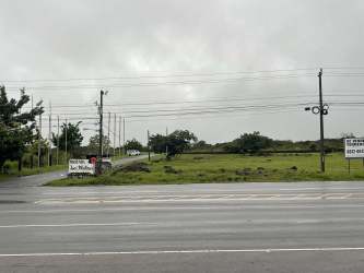 Vacant land parcel with grassy terrain, signboard and mountain backdrop in Boquete for sale