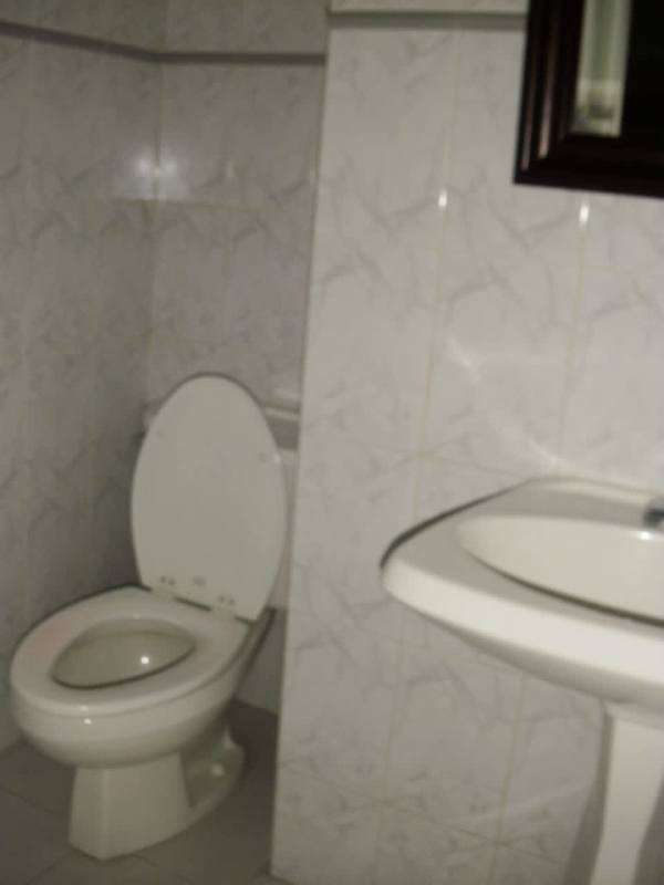 Private office bathroom with tiled walls, pedestal sink, and mirror in Ocean Business Plaza