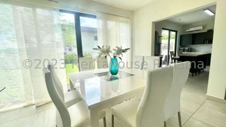 Open plan living dining room with large windows, tile floors, exit to backyard terrace at PH Nativa Panama Pacifico