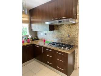 Modern kitchen with granite countertops, wood cabinets, large windows in Villas del Pinar Arraiján Panama