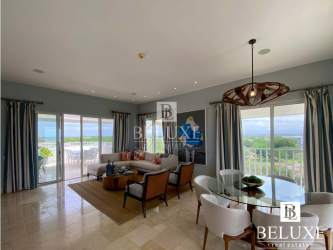 Spacious living room with floor-to-ceiling glass showcasing Pacific Ocean at Puntarena Luxury Penthouse River Hato