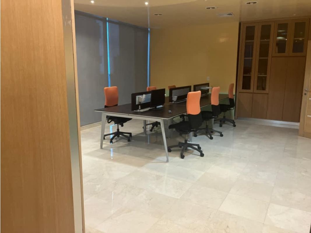 Open plan office area with orange ergonomic chairs, multiple desks in PH Torre Global Panama