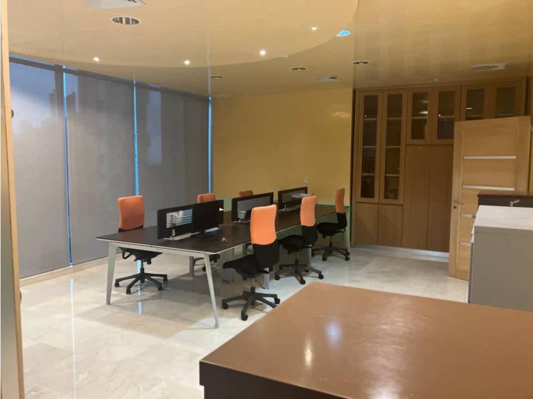Bright commercial office workspace featuring glass partition, shared desks and roller blinds PH Torre Global Calle 50