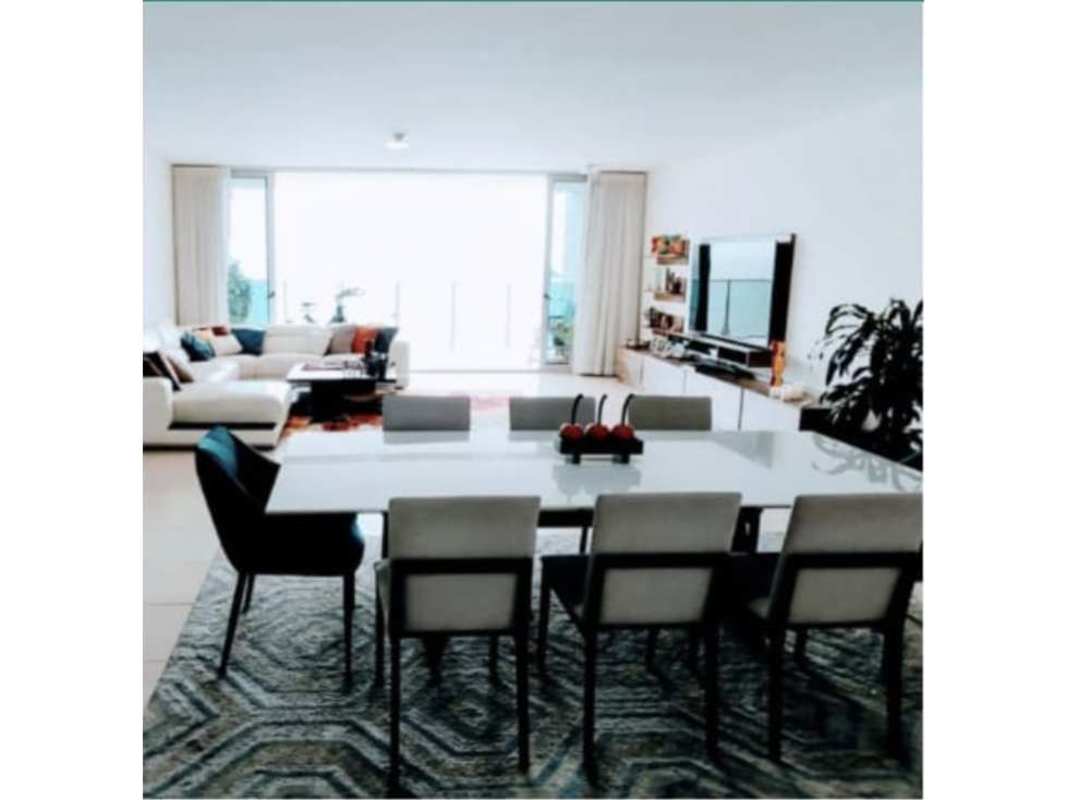 Open concept living and dining area with ocean view windows in Waters on the Bay Panama City