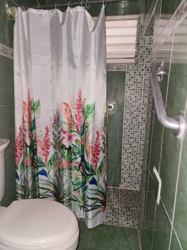 Compact bathroom with green tile walk-in shower toilet small window Villa Rica Pueblo Nuevo Panama City